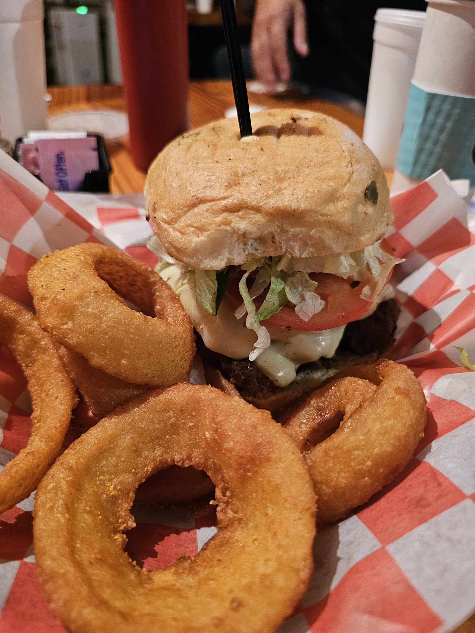 Cheeseburger with beer-battered onion rings in a checkered basket
