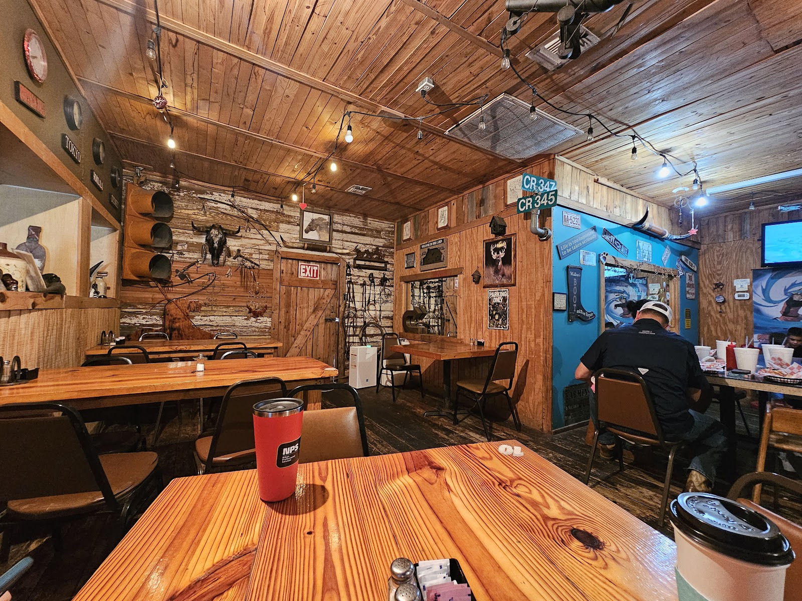 Rustic wood-paneled dining room inside Buffalo Joe's with string lights and cowboy decor